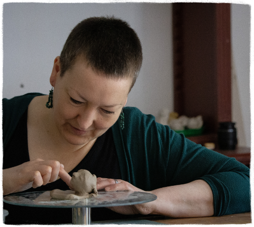 Vera Berg modelliert Blütenkind-Plastik aus Ton Vera Berg in Nahaufnahme beim Entstehungsprozess einer Blütenkind-Plastik.