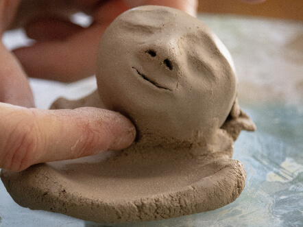 haende am ton bluetenkind nahaufnahme