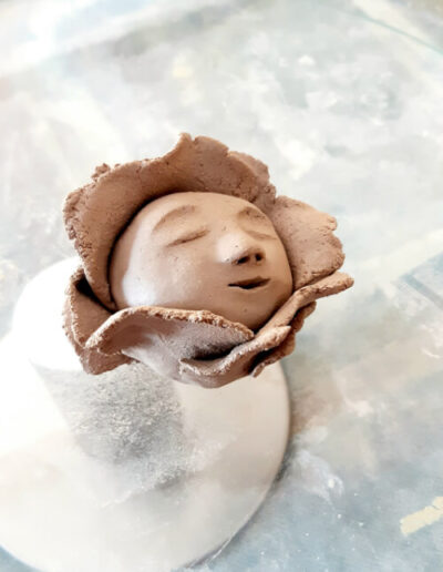 Eine Blütenkind-Plastik steht mittig auf einem Glasdrehteller frisch nach der Entstehung und zum Aushärten.